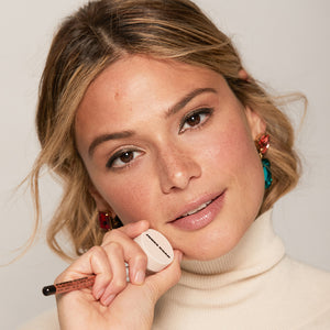 A woman wearing Jones Road Beauty's Just A Sec eyeshadow and The Best Pencil in her hand